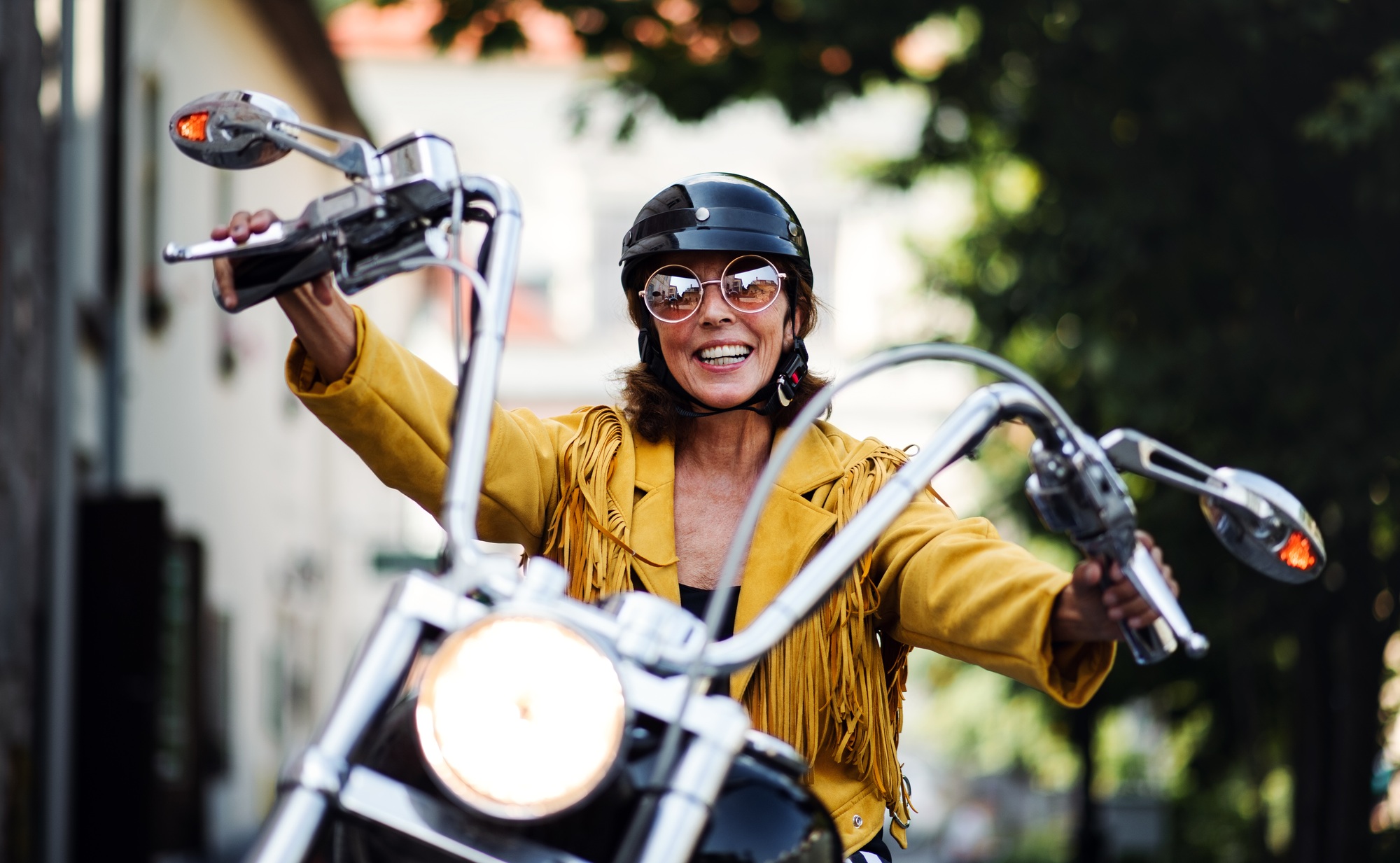 Femme âgée enjouée, voyageuse à moto en ville