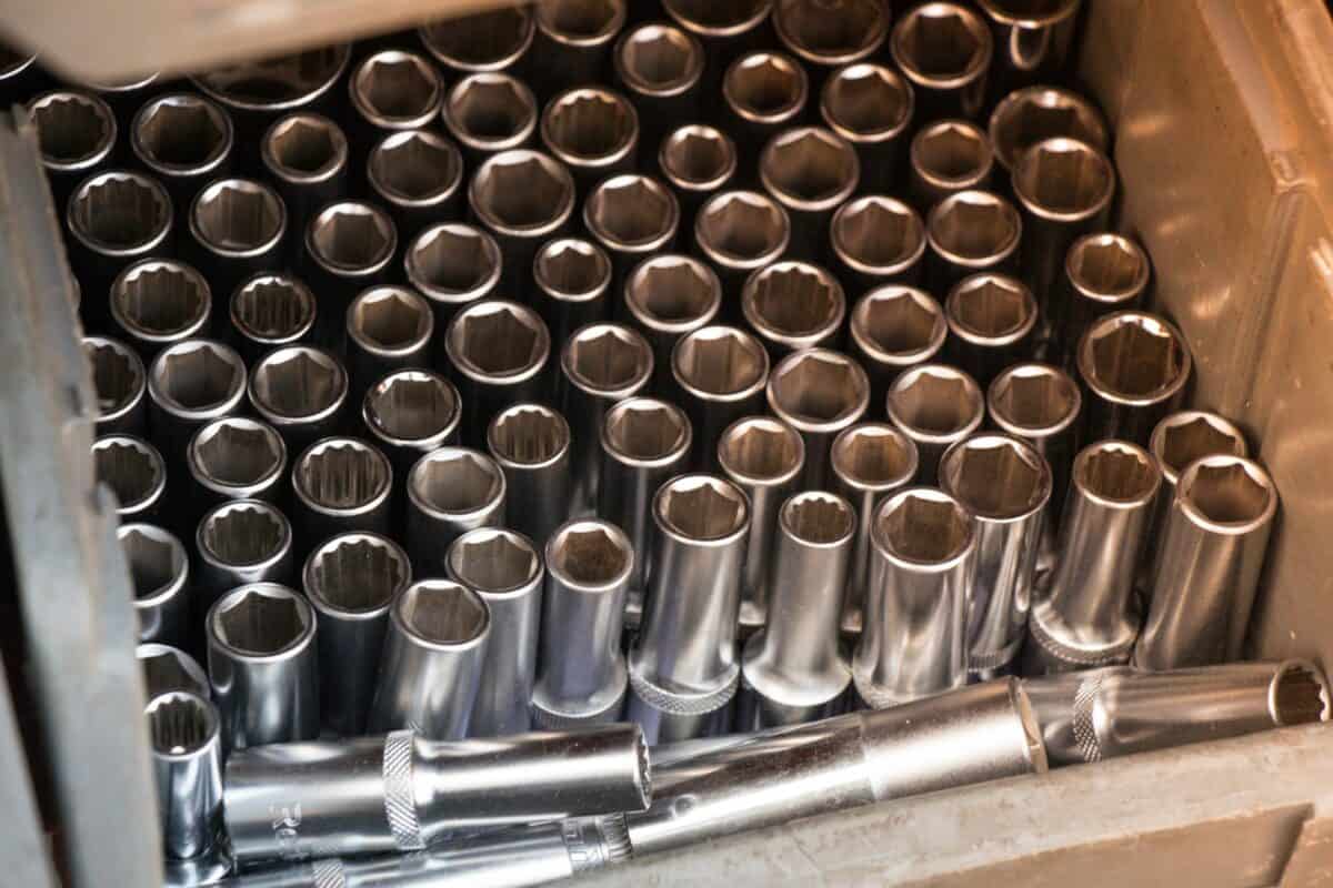 High angle shot of a box full of metallic wrenches under the light