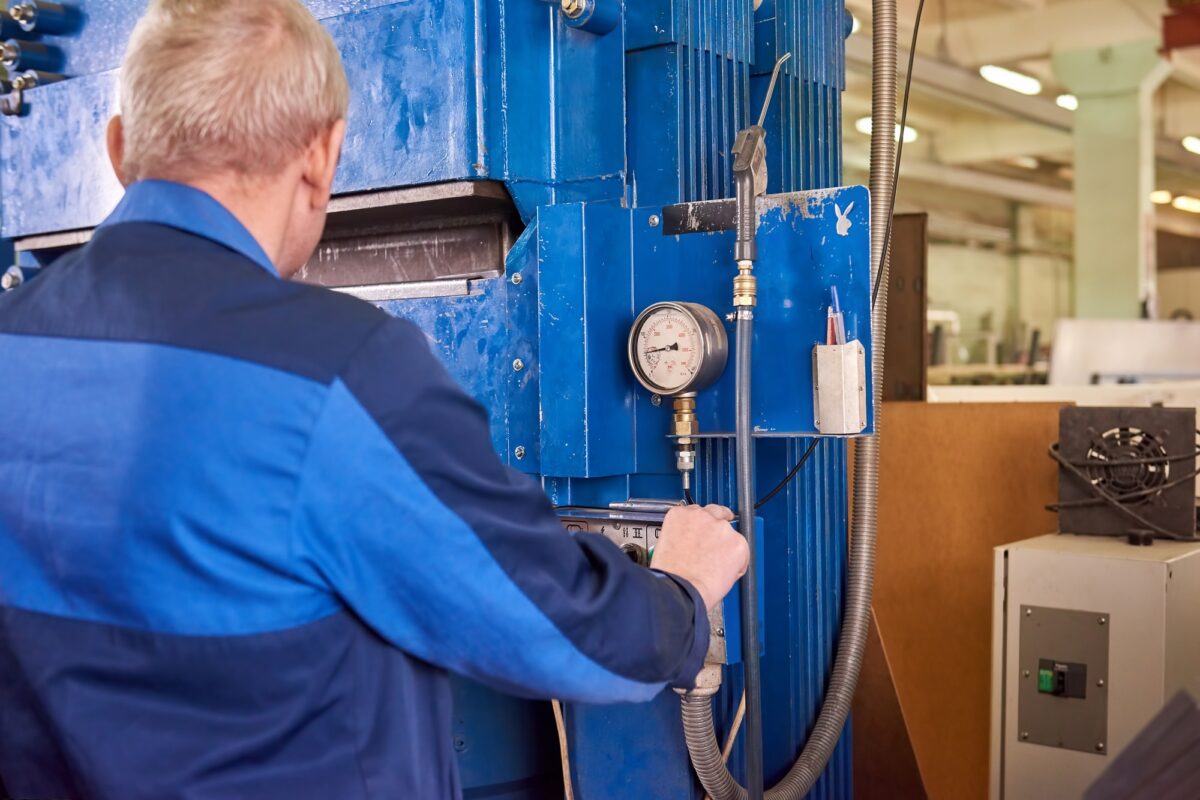 Man operating hydraulic press machine.