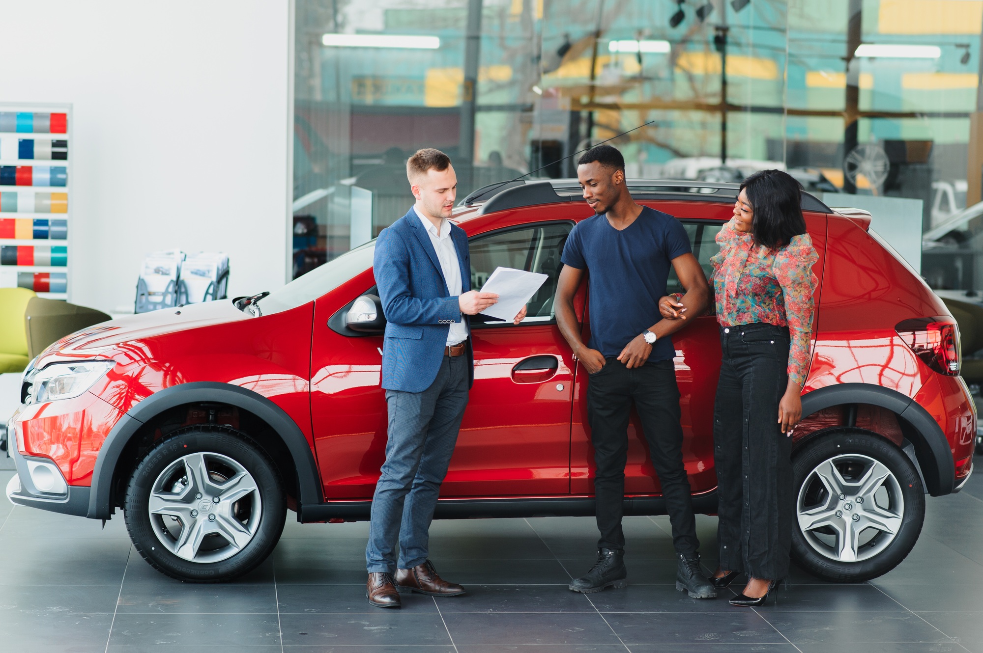 jeune couple africain achetant une nouvelle voiture chez un concessionnaire
