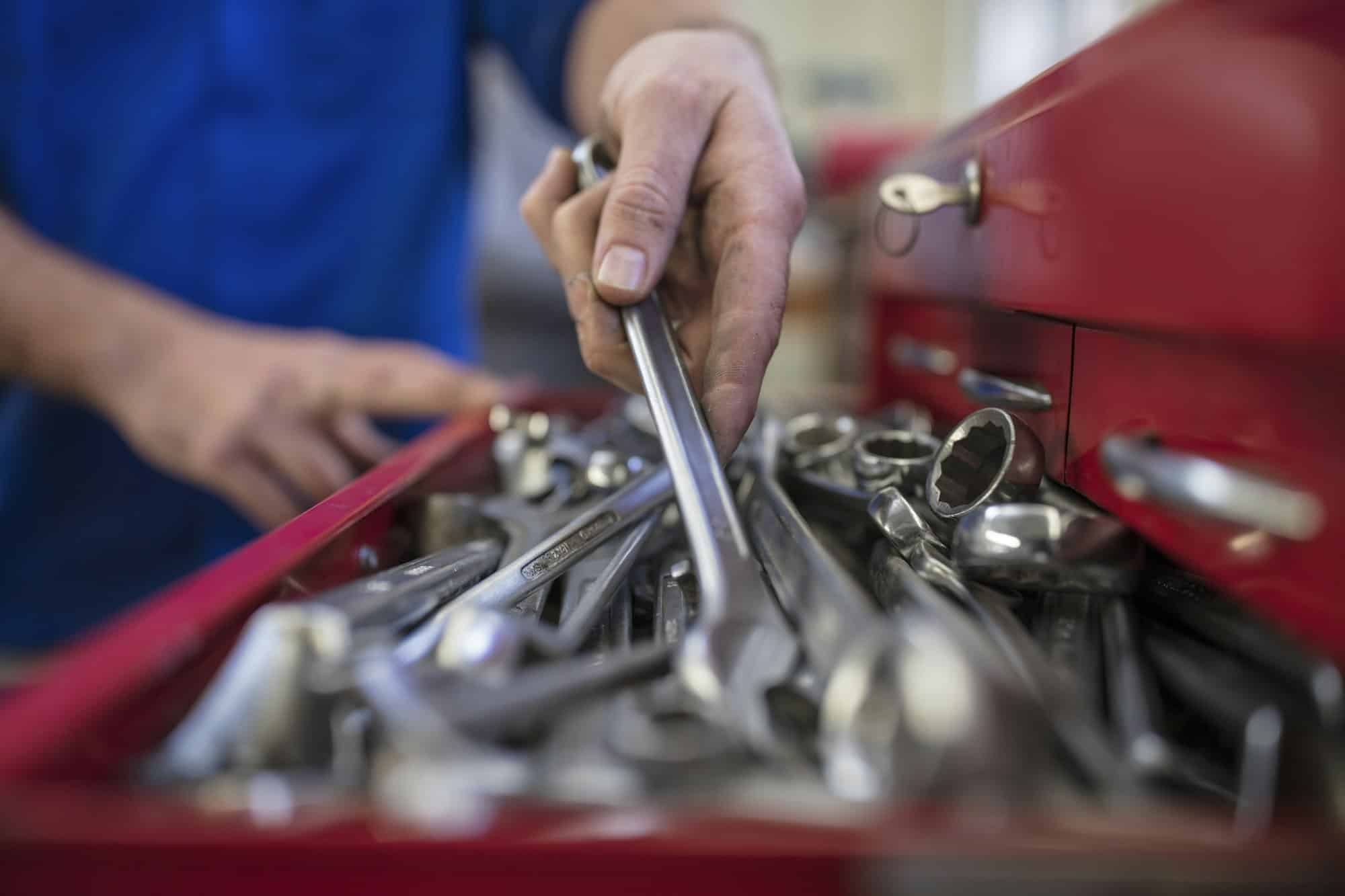 Mechanic selecting a tool from a toolbox.