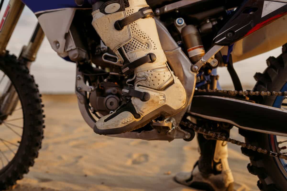 Moto trial lors d'une compétition de motocross gros plan sur les bottes du pilote