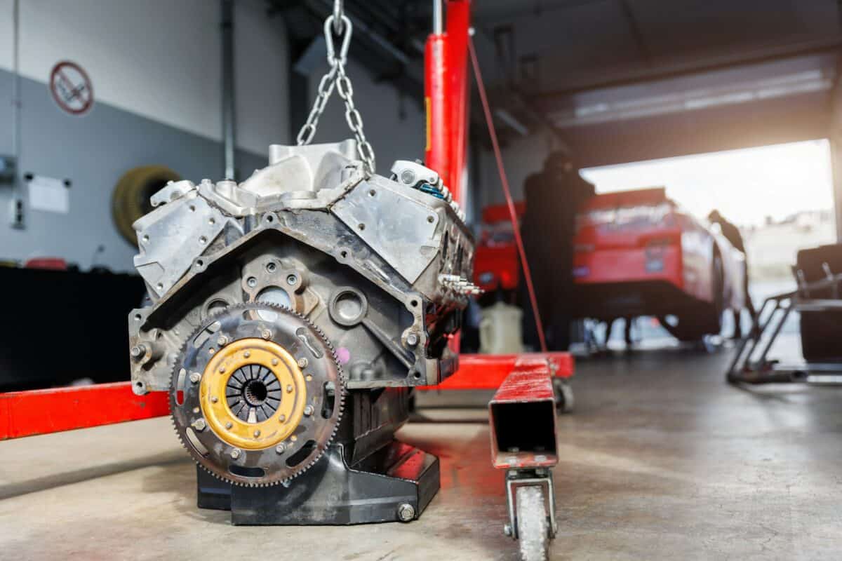 Motorsport pit lane garage box paddock hanged v8 engine suspended crane lift chain hook. Racing