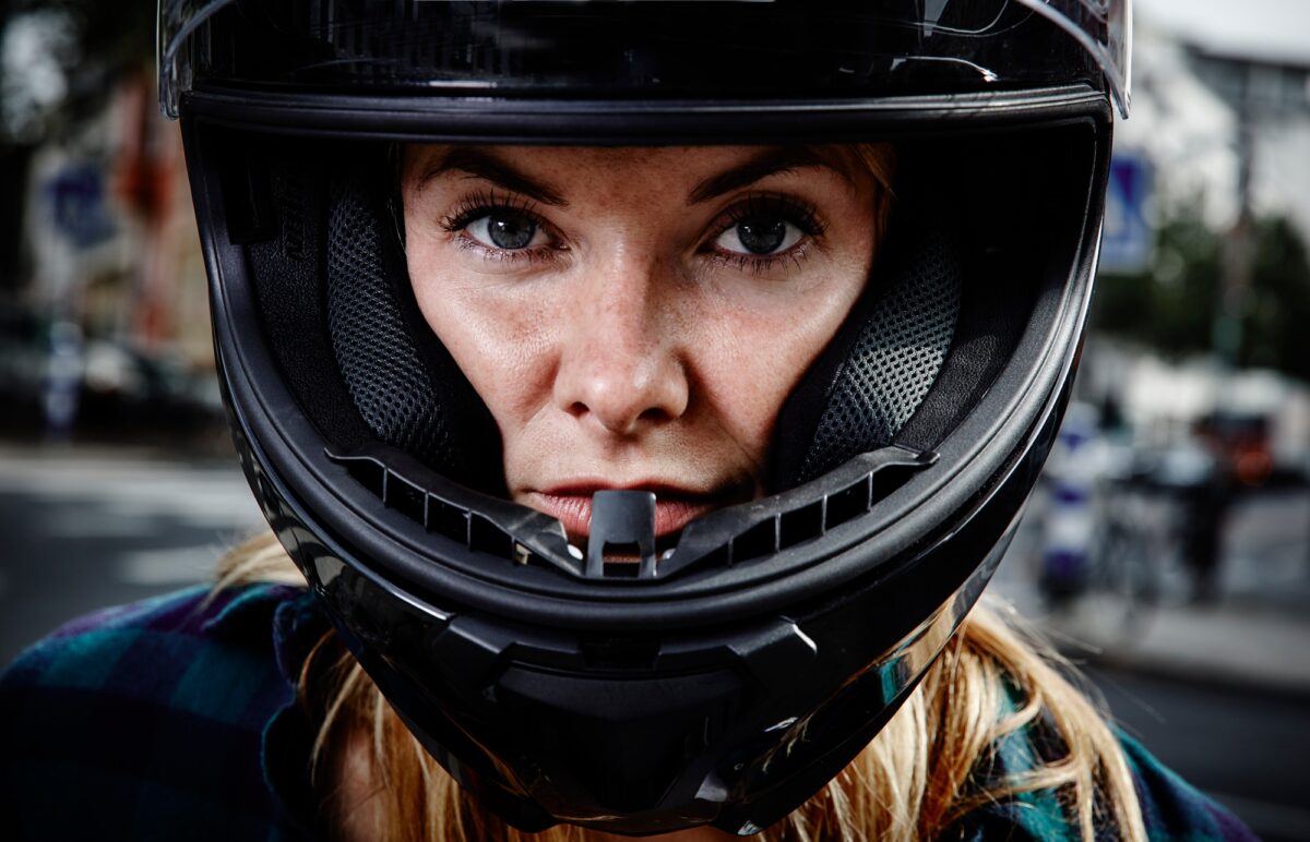 Portrait d'une jeune femme confiante portant un casque de moto