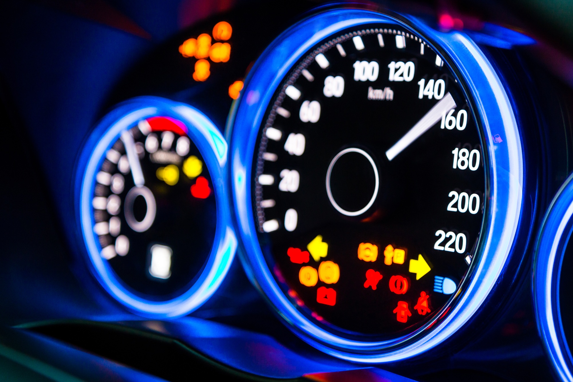 Tableau de bord de voiture moderne avec affichage illuminé bleu et affichage de tous les signes à DEL, montée en régime.
