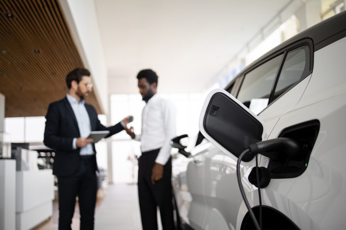 Un concessionnaire vend un SUV électrique à un homme d'affaires dans une concession automobile