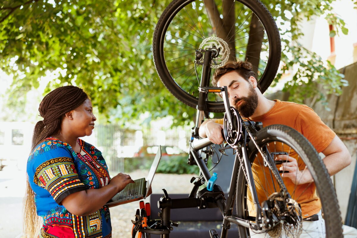 Sportloving couple with laptop fix bike