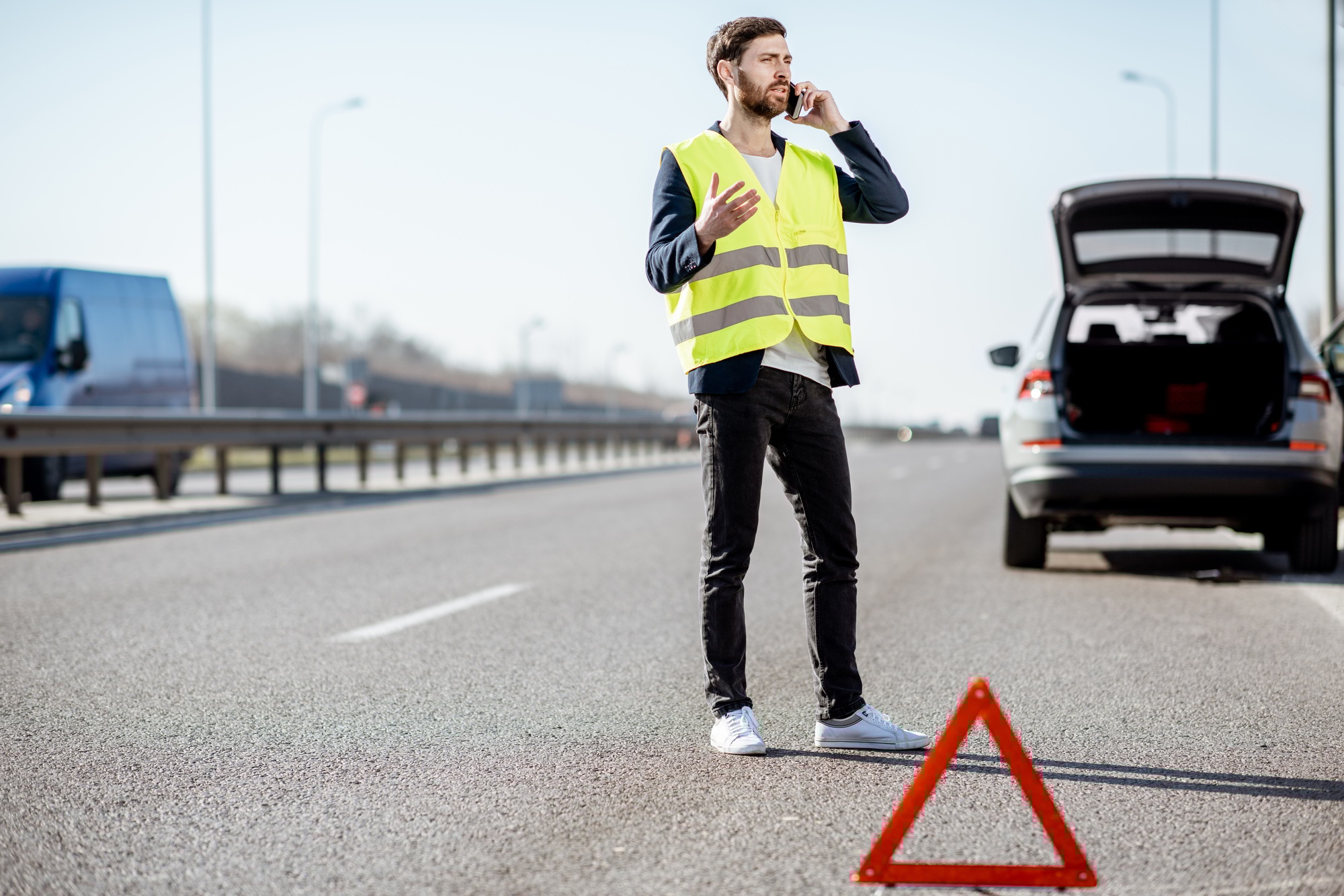 Un homme appelle l'assistance routière sur l'autoroute
