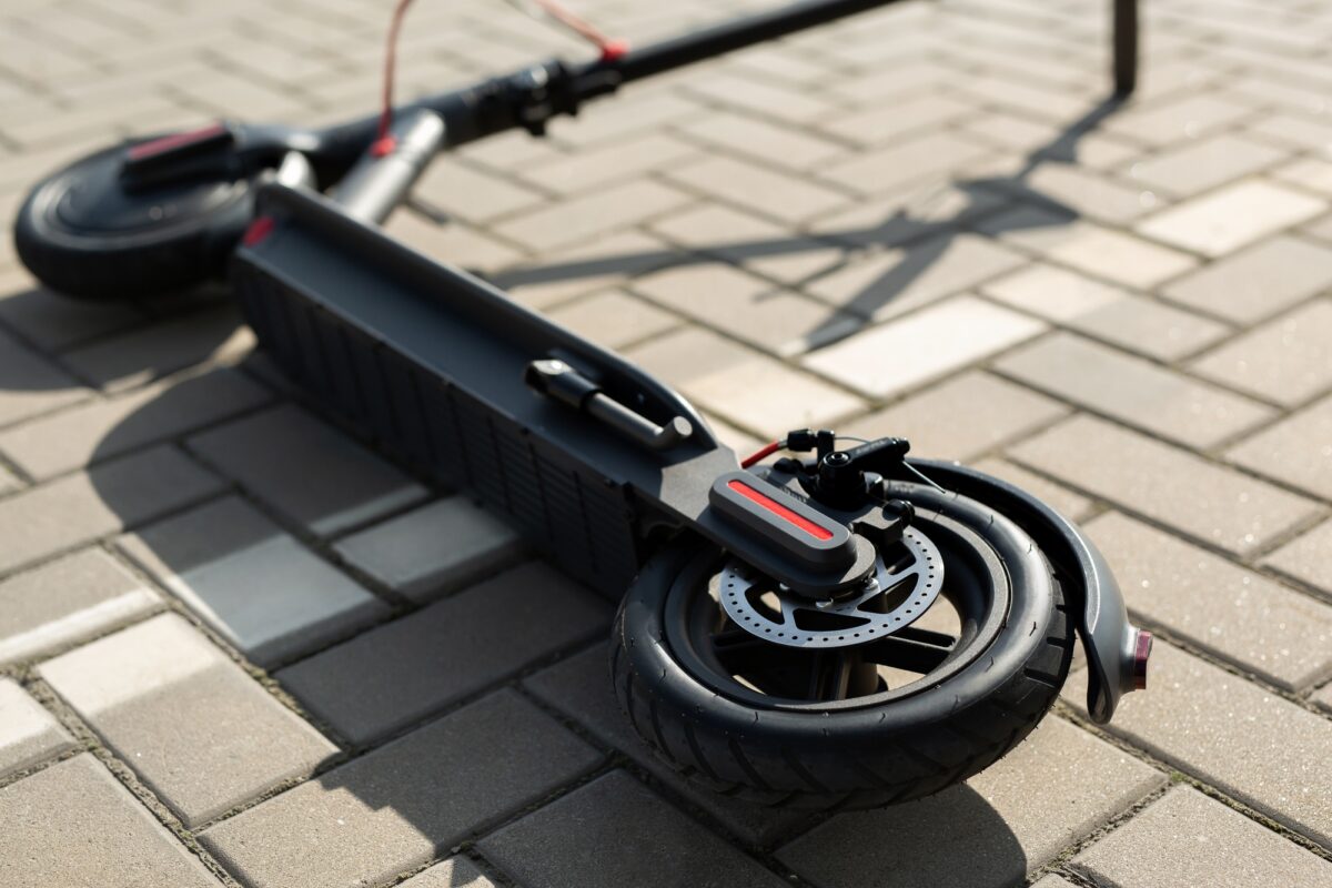Un scooter électrique est couché sur le trottoir