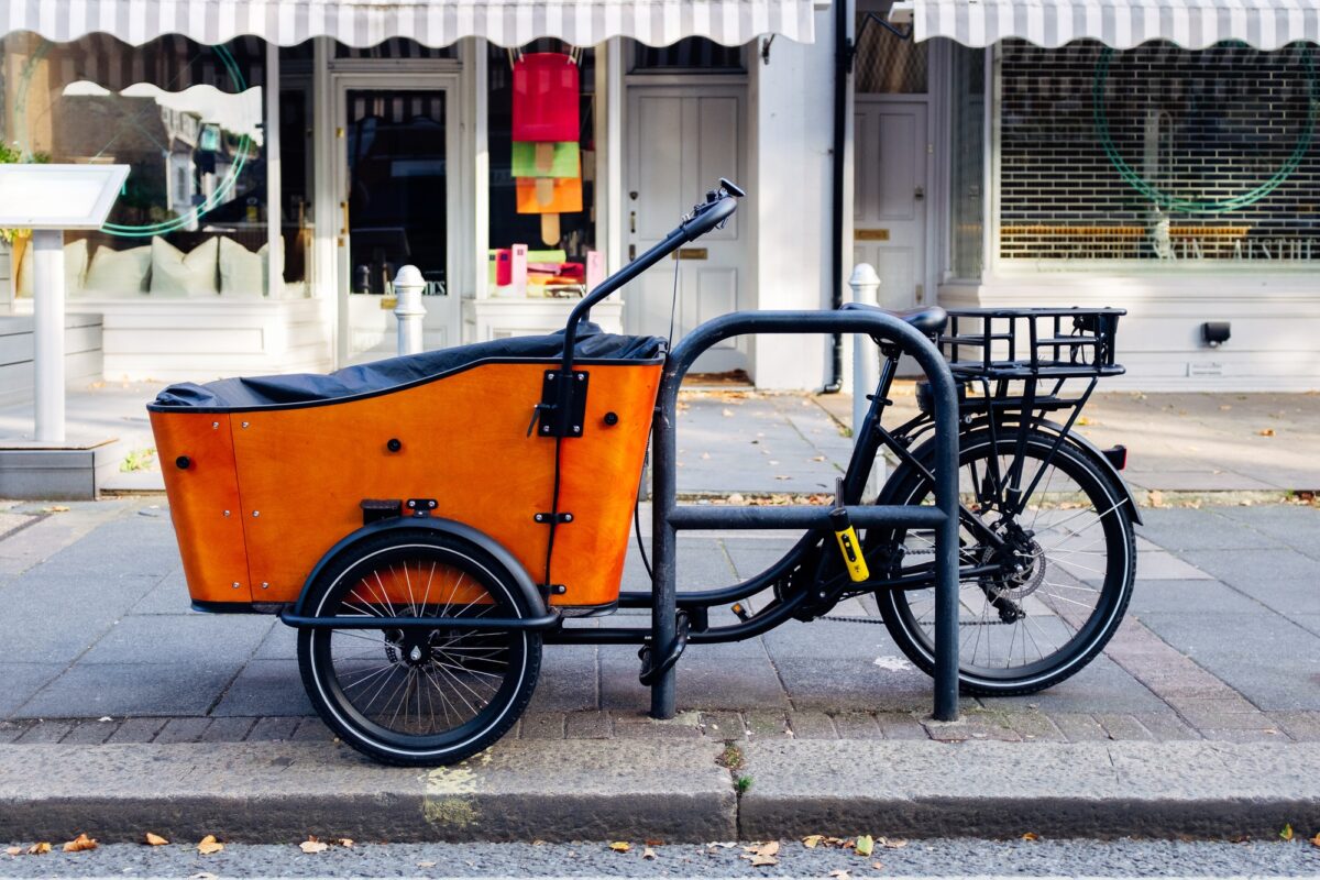 Vélo cargo orange garé sur un trottoir londonien